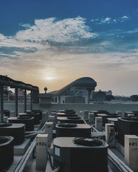 Buildings by sea against sky during sunset