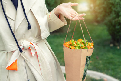 Close-up of hand holding umbrella standing outdoors