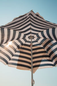 Low angle view of umbrella against clear blue sky