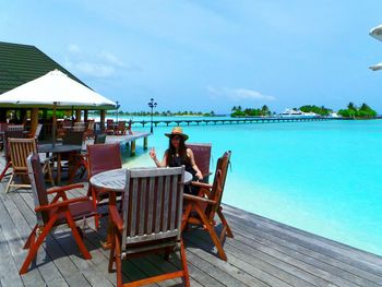 Man sitting on chair at seaside