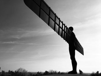 Low angle view of silhouette person standing against sky