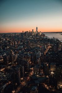 Aerial view of city lit up at sunset