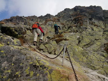 Low angle view of hikers climbing mountains