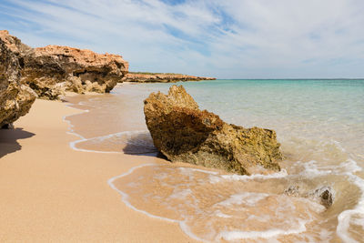 Rocks on beach against sky