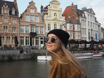 Portrait of woman against buildings in city