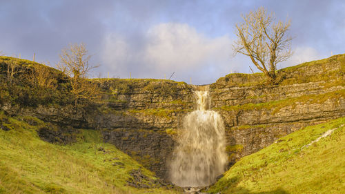 Scenic view of waterfall against sky