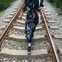 Low section of woman walking on railroad track