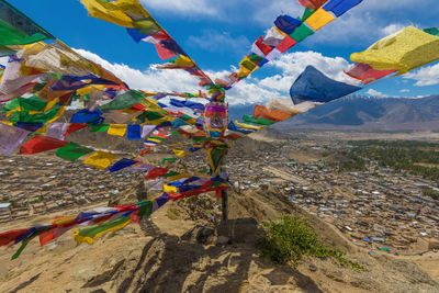 Multi colored flags on landscape against sky