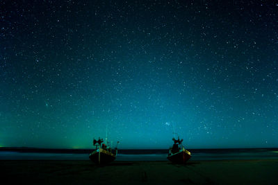 Scenic view of sea against star field at night