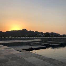 Scenic view of swimming pool against clear sky during sunset