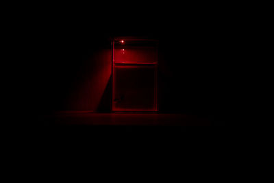 Close-up of red wine glass on table against black background