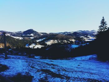 Scenic view of snowcapped mountains against clear blue sky