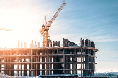 Construction of multi-storey building. cranes. sunlight on construction site.