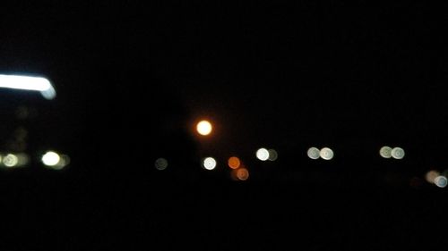 Low angle view of illuminated lights against sky at night