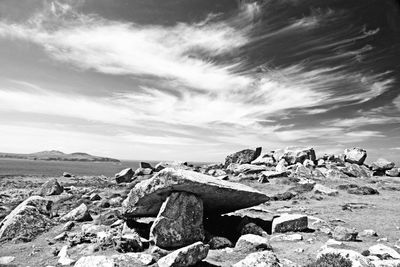 Rocks at on beach against sky