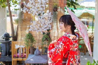 Side view of young woman looking away outdoors