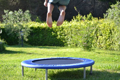 Low section of boy jumping on trampoline in park