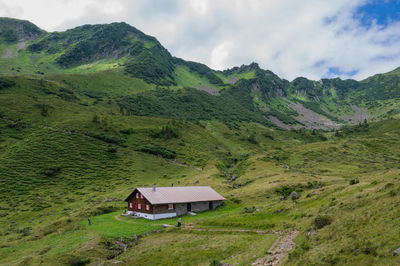 Scenic view of house and mountains against sky