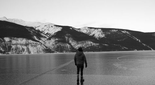 Rear view of man against mountain against clear sky