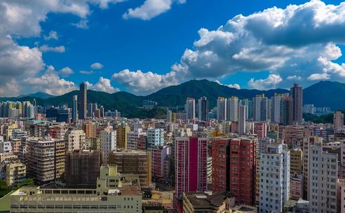 Aerial view of buildings in city against sky