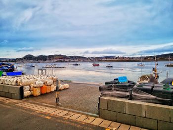 Boats moored in harbor against sky