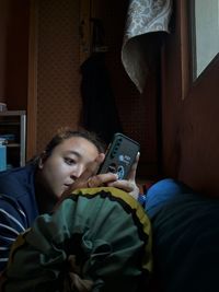 Portrait of boy using mobile phone at home