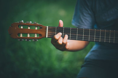 Midsection of person playing guitar