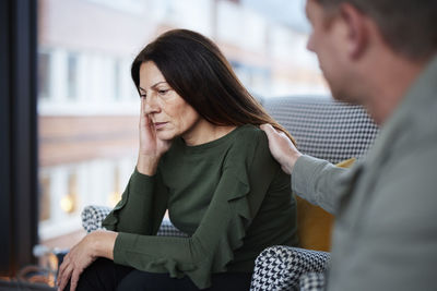 Man touching mature woman's shoulder