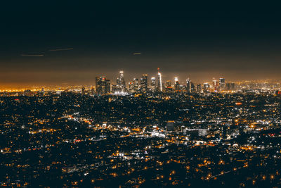 Illuminated cityscape against sky at night