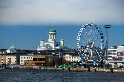 Ferris wheel in city against buildings