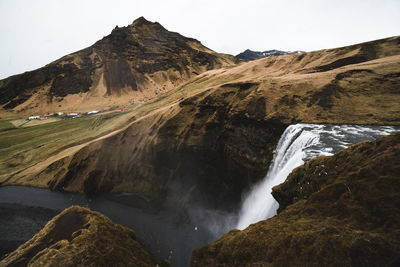 Scenic view of waterfall against sky