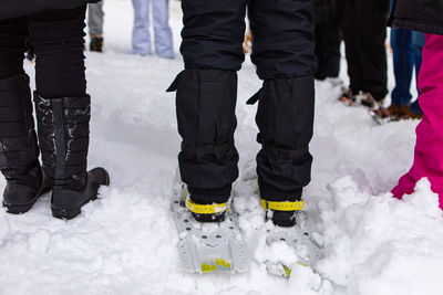 Low section of people standing on snow covered landscape