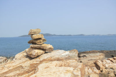 Stack of rocks on beach against clear sky