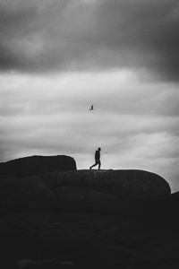 Silhouette of person paragliding against sky