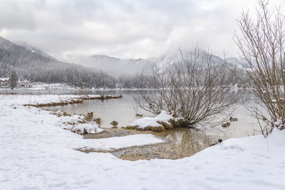 Scenic view of lake against sky during winter