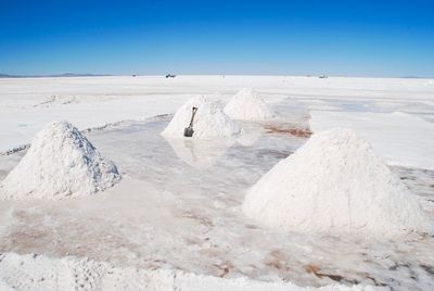 Scenic view of snow covered landscape against blue sky