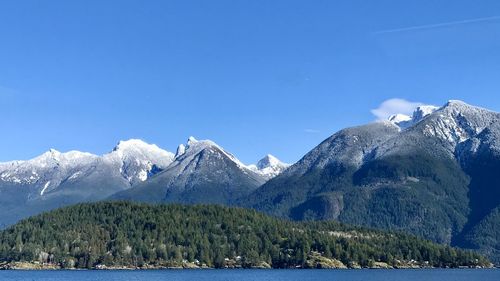 Scenic view of snowcapped mountains against blue sky