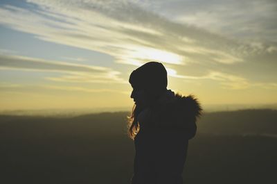Silhouette of woman against sky during sunset