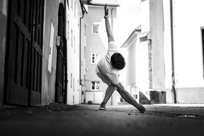 Young man exercising by building