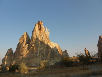 Rock formations on landscape against clear sky