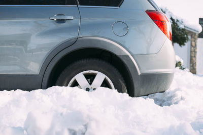 Car with wheel stuck in snow after heavy snowfall