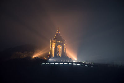 Illuminated building against sky at night