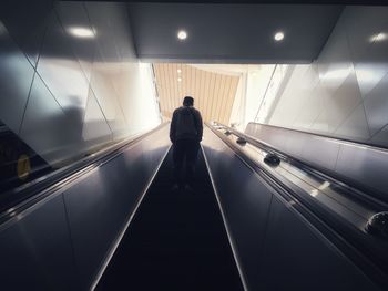 Rear view of man on escalator