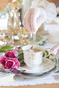 English retro still life and a woman's hand in a white lace glove stirring coffe