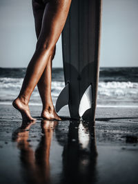 Low section of woman standing on beach