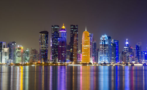Illuminated buildings against sky at night