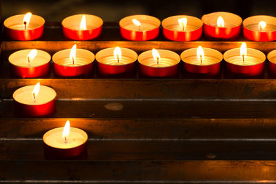 Illuminated tea light candles in temple