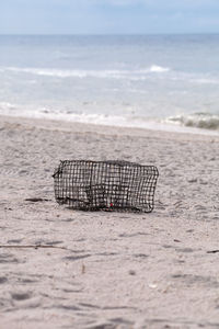 Crab and lobster trap washed up on the white sand beach of tigertail beach on marco island, florida.