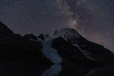 Scenic view of snowcapped mountains against sky at night