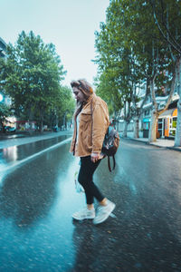 Woman with umbrella on street in city